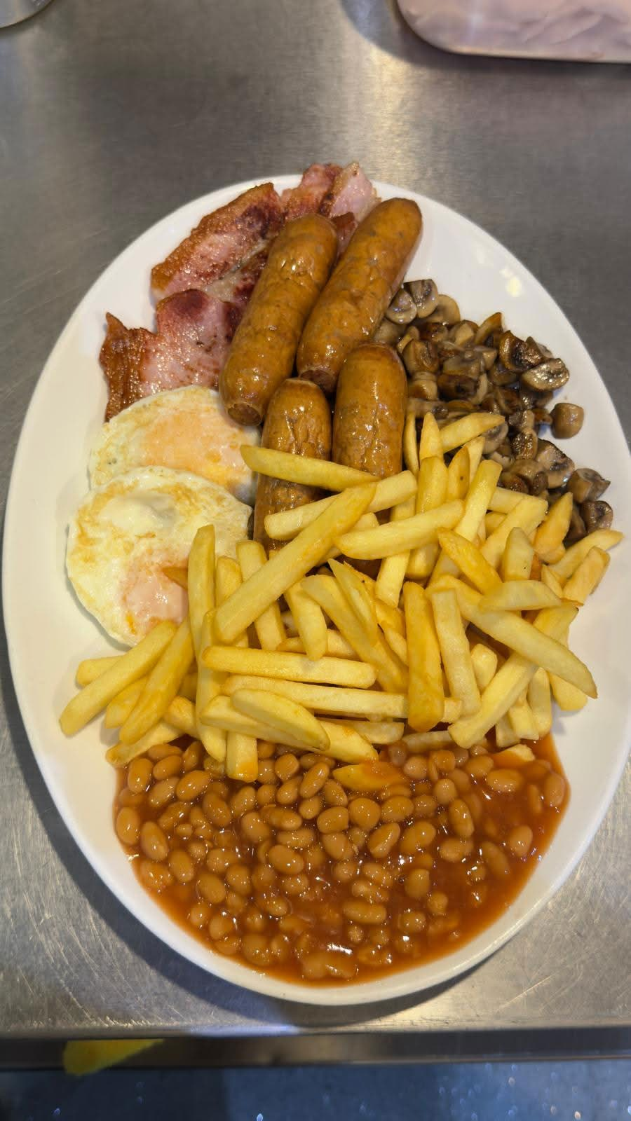 Close-up of a full English breakfast with sausages, egg and chips at Tasty Cafe