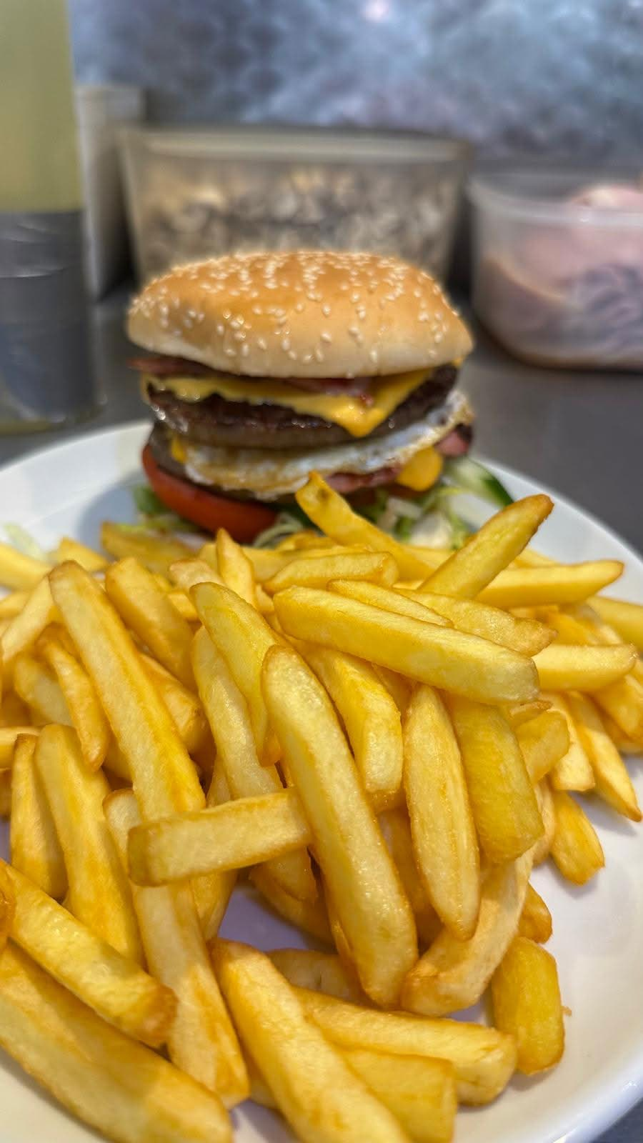 Close-up of a cheeseburger and chips at Tasty Cafe